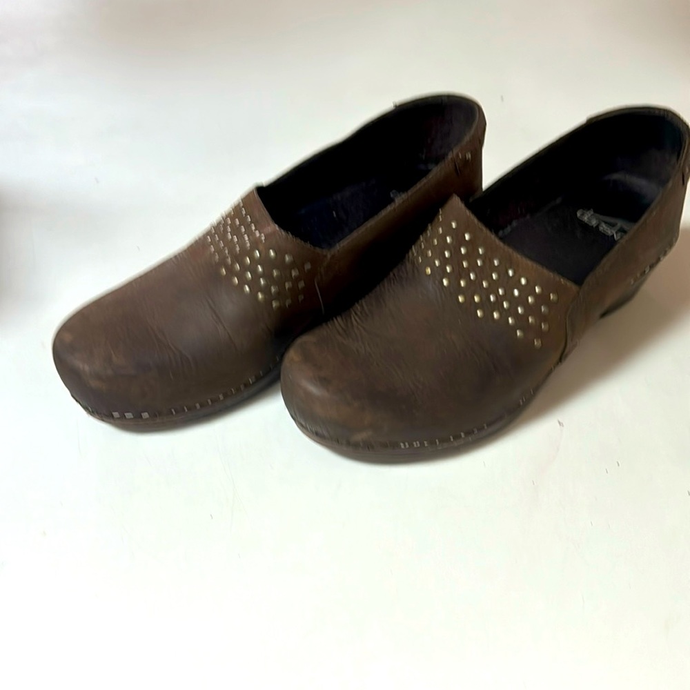Dansko brown leather with brass rivet detail.